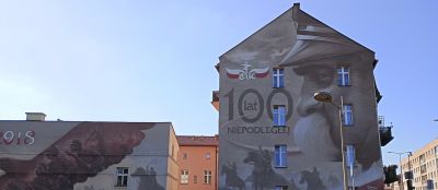 1918, 100 år av självständigt och Józef Pilsudski i profil. På en parkbänk mittemot denna vägg sitter...